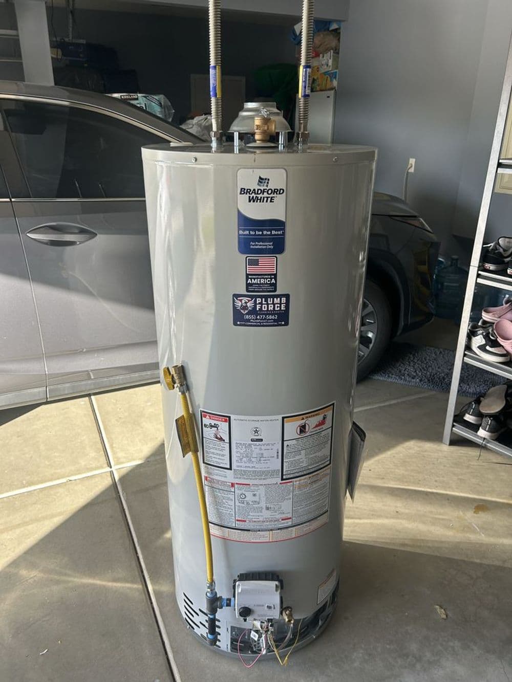 New Bradford White water heater positioned in a garage with safety information labels visible.
