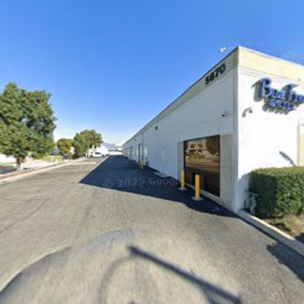 Exterior view of a commercial building with a clear sky and parking area.