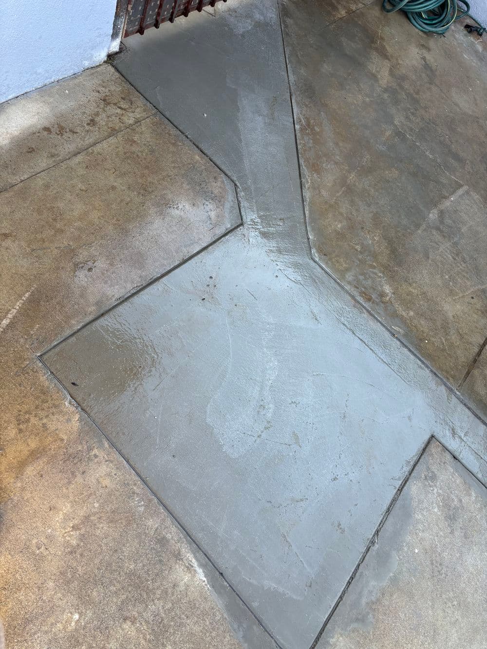 Freshly poured concrete slab in a geometric design, showcasing smooth finish and clean edges.
