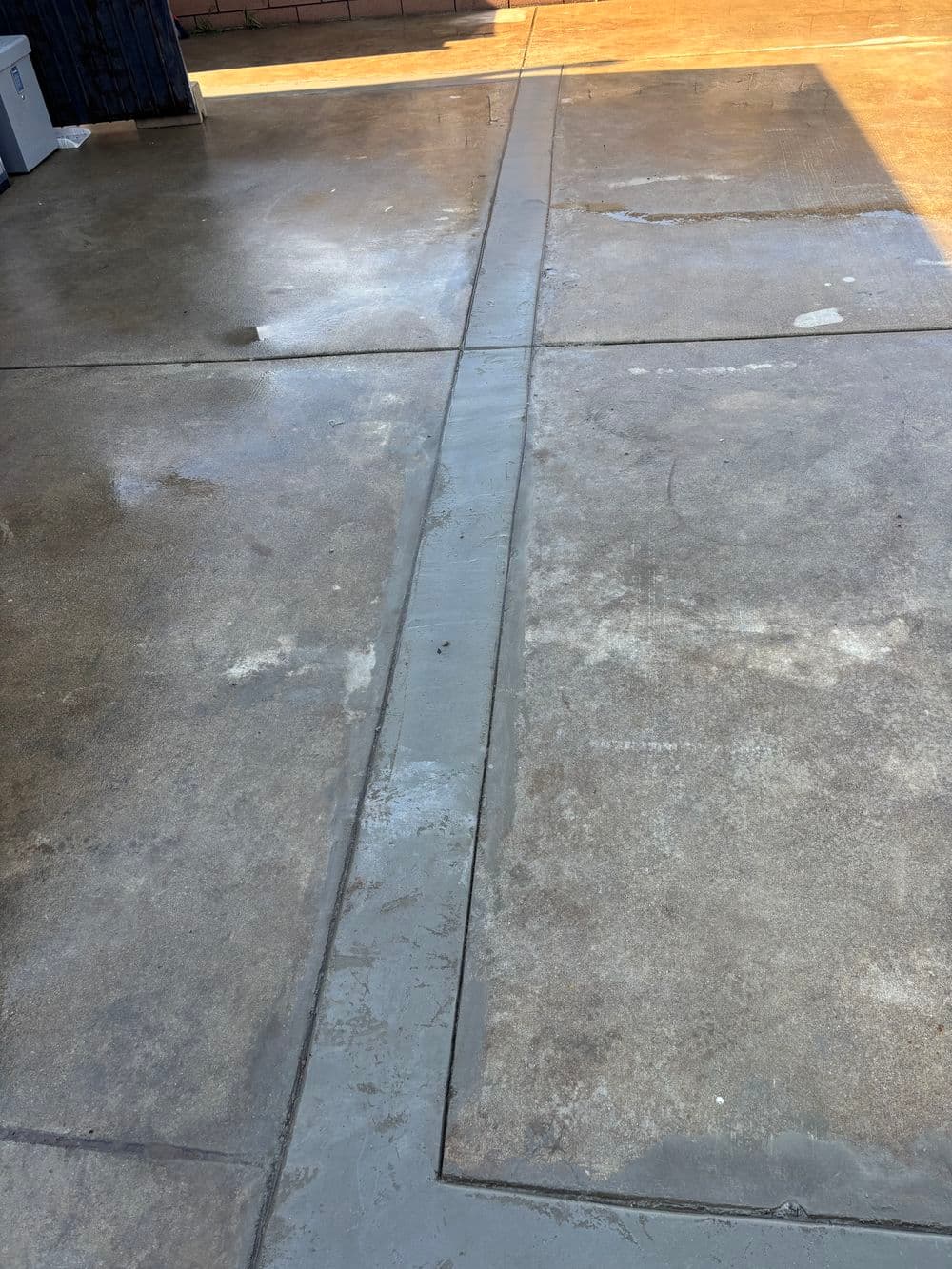 Freshly poured concrete seam on a garage floor, showcasing smooth surface and clean finish.